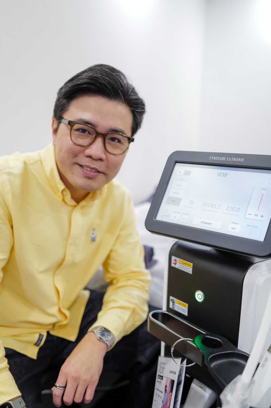 Dr Ong Jin Khang standing beside the XERF console at a clinic overseas