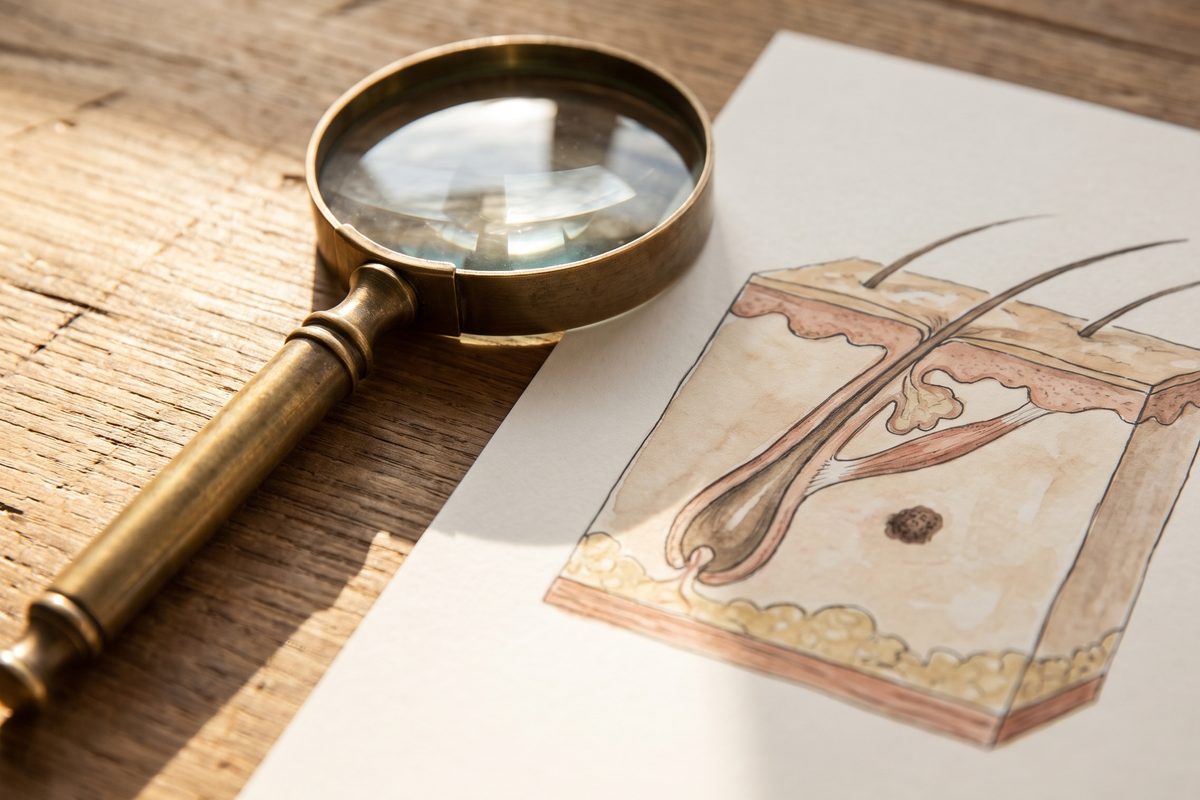 A folded cotton cloth, a small round glass dish and a single pebble on pale stone in soft daylight, a quiet still life with no skin, faces, needles or packaging