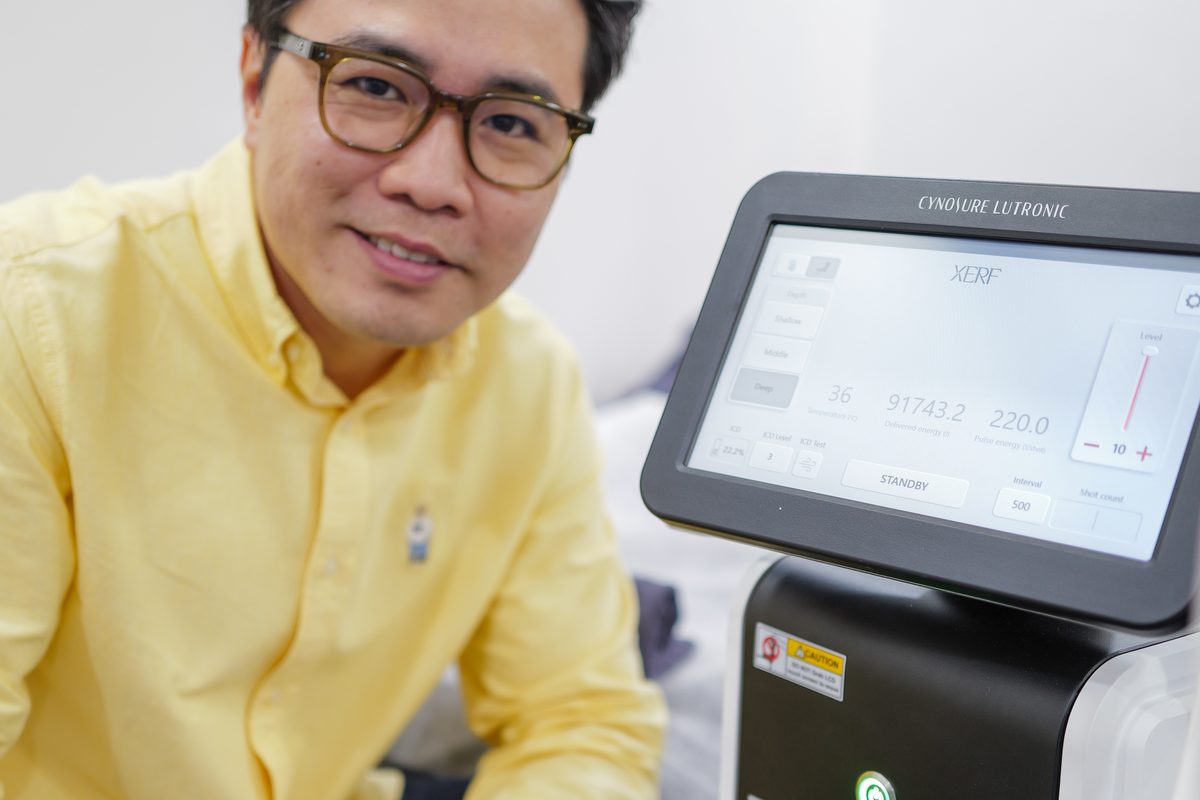 Dr Ong Jin Khang holding the XERF handpiece, a close documentary photograph showing the device in a clinical setting with no patient present