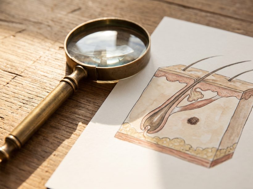 A folded cotton cloth, a small round glass dish and a single pebble on pale stone in soft daylight, a quiet still life with no skin, faces, needles or packaging